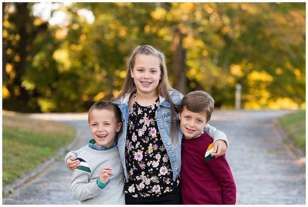 Three children smile for the camera