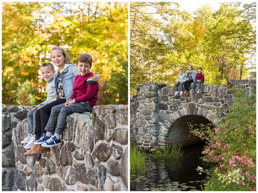 Three children sit on a stone bridge