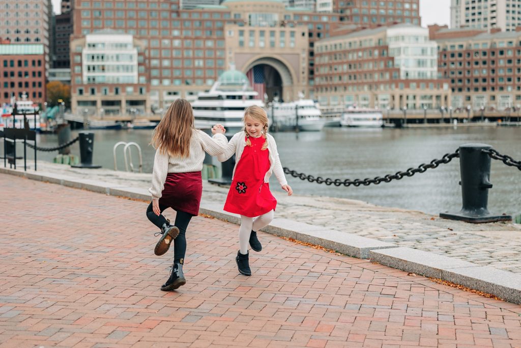 Two sisters do an Irish Jig in front of the Boston Skyline