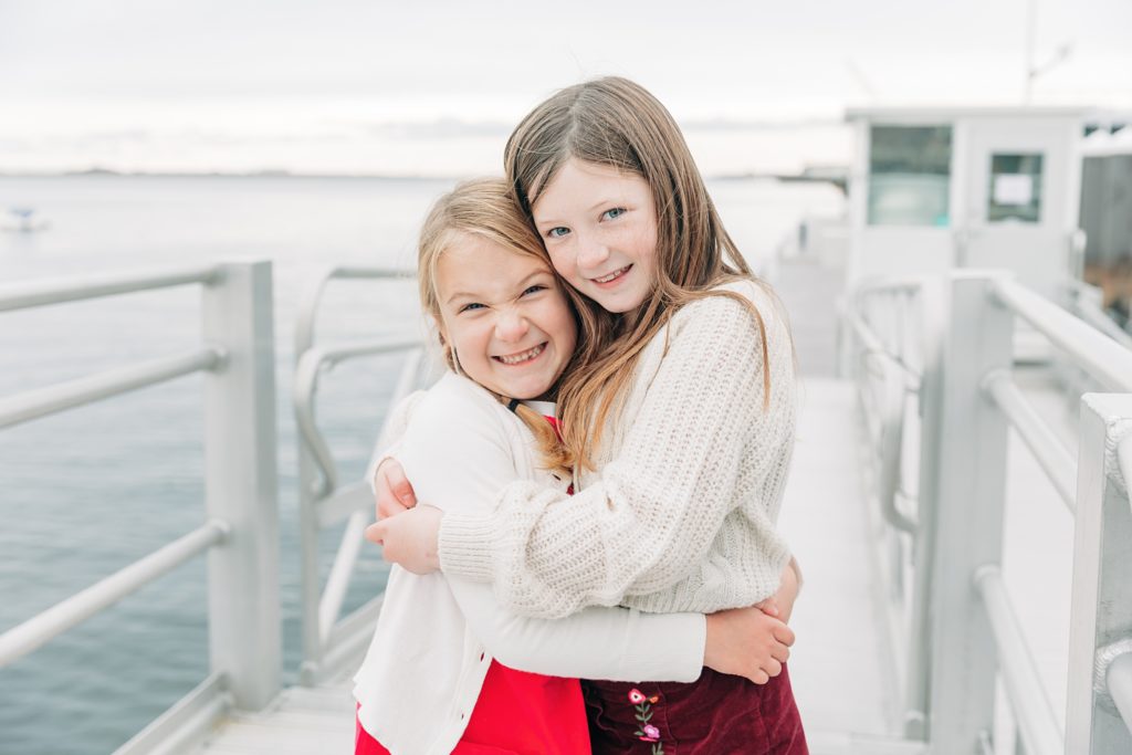 Two sisters hug on the marina walkway