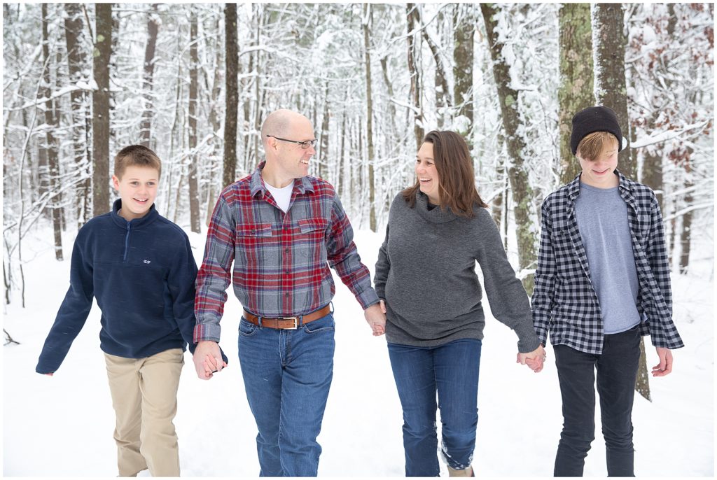A family walks along a snowy trail