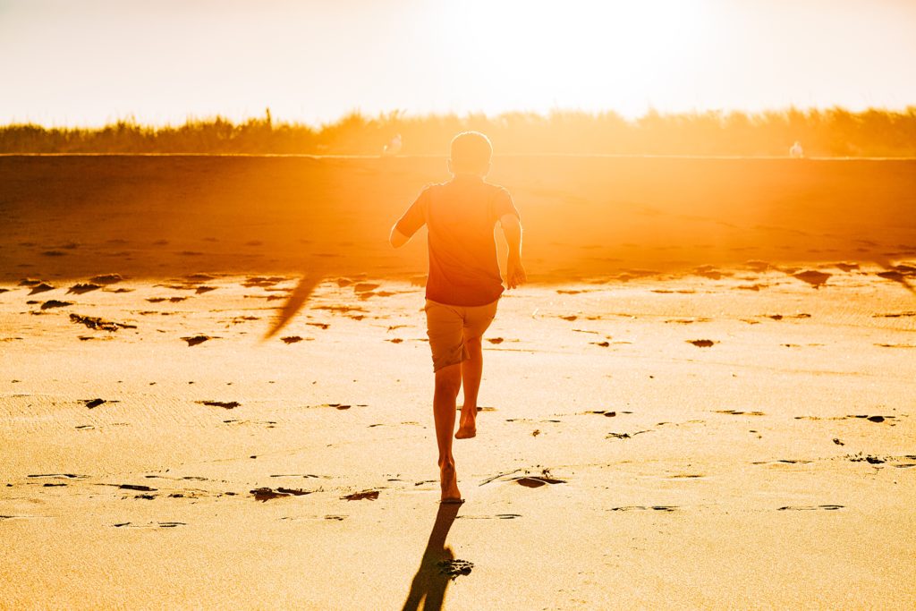 A boy runs at sunset